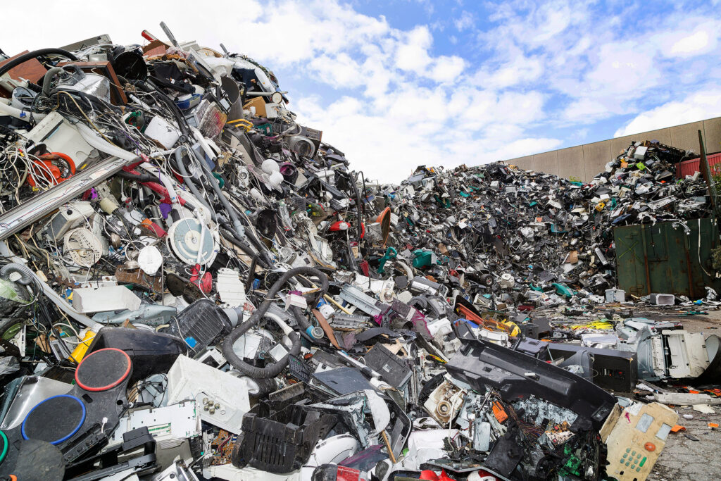 Landfill with a large pile of discarded electronics highlighting the importance of electronics recycling.