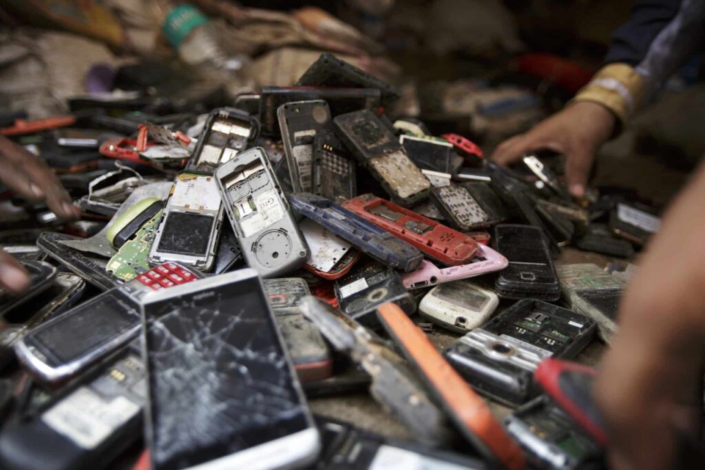 Piles of electronic waste in a landfill demonstrating the importance of cell phone recycling.