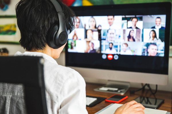 Remote worker on a Zoom call in a home office setup.